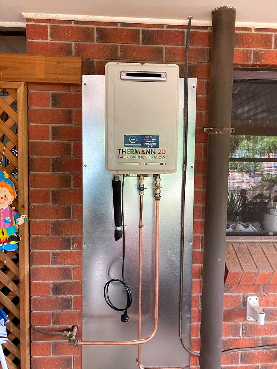 A Thermann gas continuous flow hot water system installed by Northern Plumbing and Hotwater on a brick wall in Adelaide